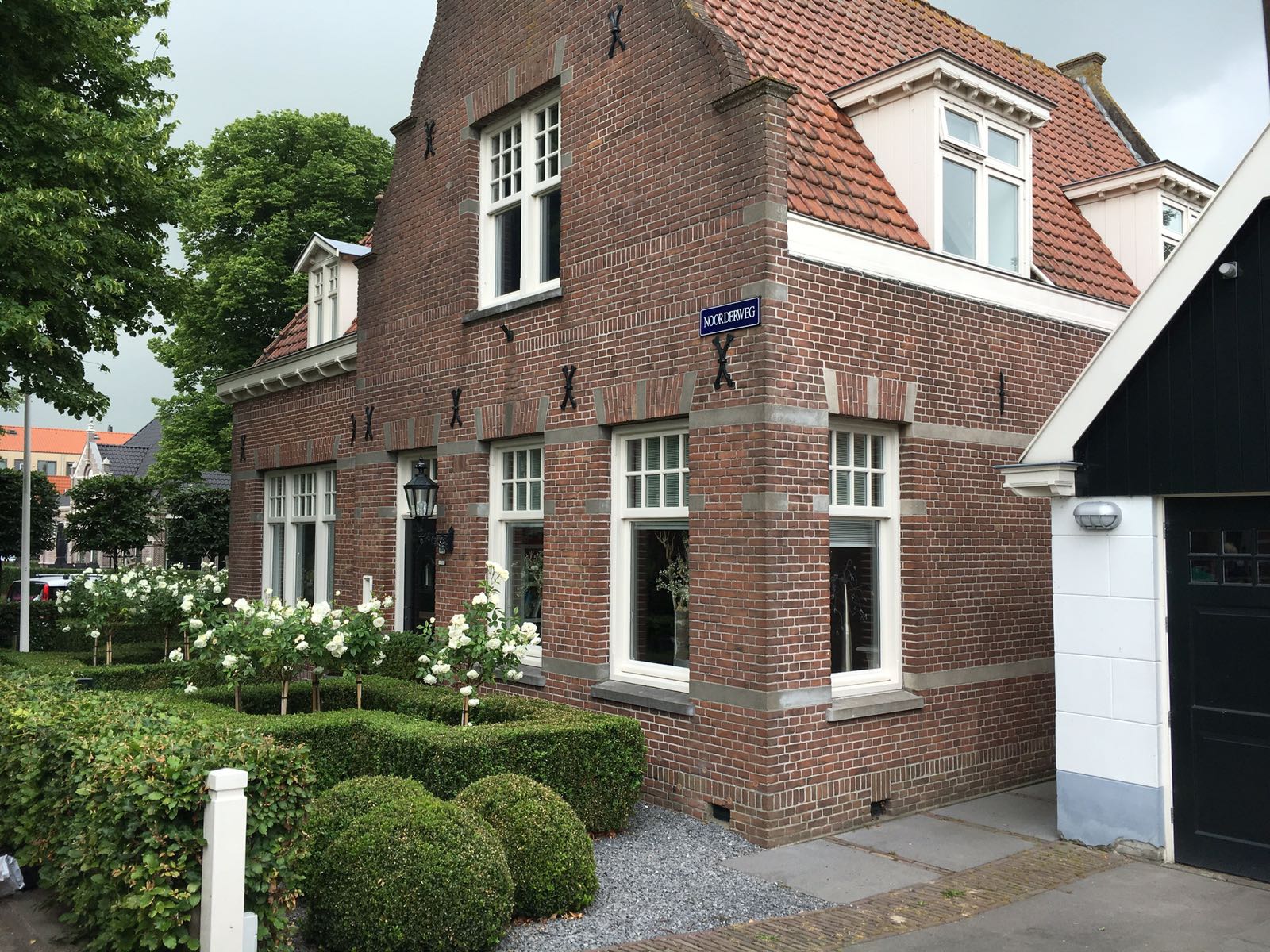 Klasieke tuin in Neck met een patroon van buxushagen met daar bovenuitstekend rozenboompjes-1503